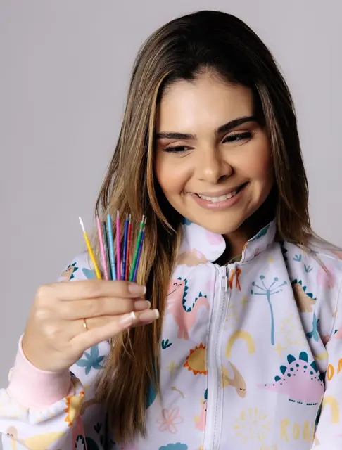 A Dra. Desirée segura escovas de dente coloridas.